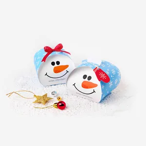 Dettaglio di scatole regalo a pupazzo di neve blu con fiocchi rossi e decori natalizi