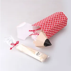 Detail of pencil-shaped candy gift box with geometric pattern and ribbon packaging set