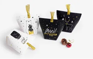Détail des boîtes cadeaux avec motifs dorés et élégantes poignées en ruban de soie
