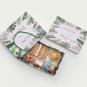 Detail view of bakery gift box with green leaf pattern and assorted snacks inside