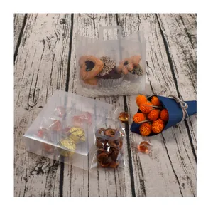 Set di sacchetti e scatole regalo trasparenti opachi con biscotti su legno