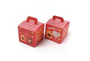 Close-up of red bear cookie gift boxes with heart window and red gingham handles