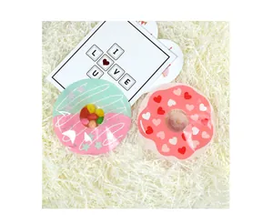 Detail of donut-shaped gift bags with heart patterns and clear windows on shredded paper