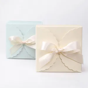 Elegant square paper gift boxes in blue and white with wavy lids and silk ribbon bows