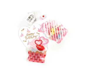 Close-up of cupcake and stripe shaped gift bags with heart handle for candy packaging