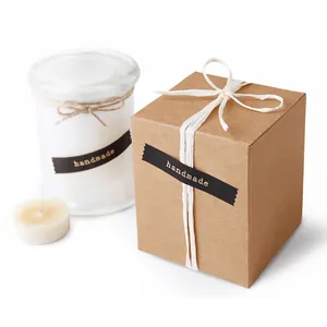 Handmade scented candle in glass jar with kraft gift box and natural raffia bow decoration
