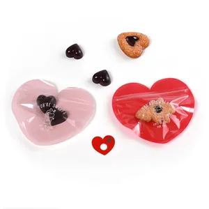 Heart-shaped self-sealing gift bags in pink and red with cute decorative white lettering