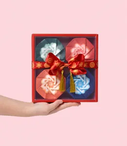 Dettaglio della scatola per mooncake rossa con coperchi a petalo e nappe dorate