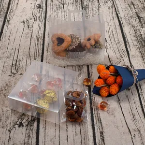 Transparent plastic gift packaging bags and boxes for candy and cosmetics on wood background