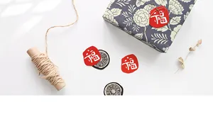 Macro shot of Fu character tags and vintage stickers on blue floral gift wrap