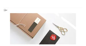 Detail of kraft gift box with red Fu character tag and vintage gold scissors