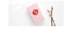 Top view of red Fu character tag on gift box with pussy willow decor for Lunar New Year