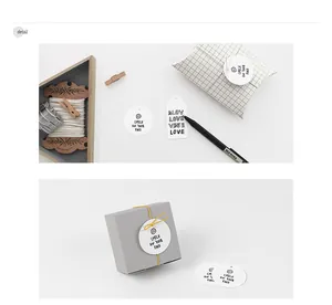 Detail of minimalist gift tags with Smile and Love text on white cardstock and gift boxes