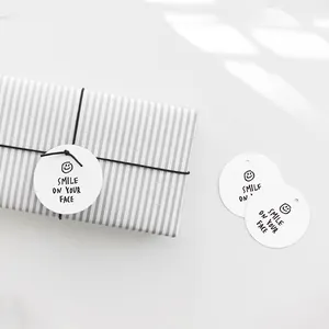Minimalist white round gift tags with smile icons and hanging string for gift packaging