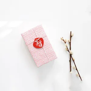 Red Fu character tag on white gift box with floral pattern and willow branch