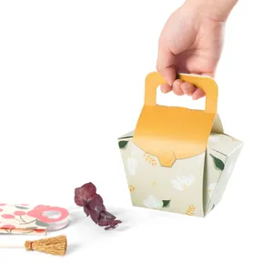 Floral paper gift box with handle for sweets and pastry presented in hand