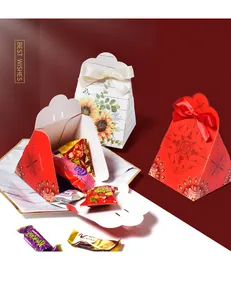 Detail of red wedding candy boxes with gold double happiness characters and satin bows