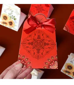 Detail of red Chinese wedding candy box with Xi character and satin ribbon bow decoration