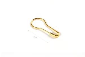 Macro shot of a 2cm golden metal pear-shaped safety pin for clothing tags and knitting
