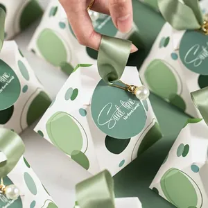 Detail of green pyramid candy box with satin ribbon handle and white pearl charm pendant