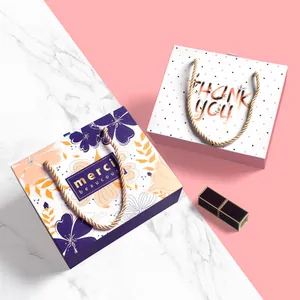 Elegant floral and polka dot wedding gift boxes with gold woven handles and merci text