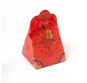 Detail of red pyramid wedding candy box with red ribbon and golden Double Happiness charm