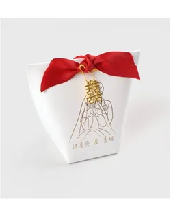 Detail of white wedding candy box with red bow and gold Double Happiness pendant