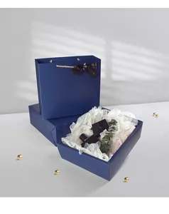 Détail d'un coffret cadeau de mariage bleu foncé de luxe avec poignées dorées et ruban