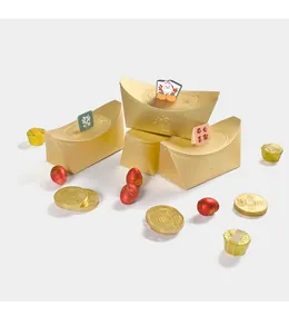 Detalle de caja de caramelos de lingote de oro con decoraciones festivas y monedas