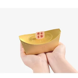 Primer plano de caja de caramelos dorada sycee con relieve Zhaocai Jinbao y etiqueta