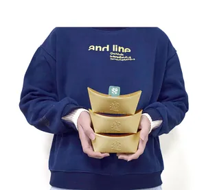 Detalle de tres cajas de dulces con forma de lingote de oro y grabados chinos