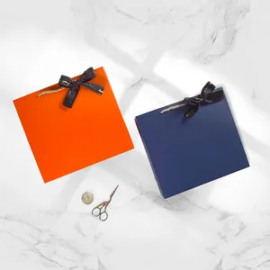 Boîtes cadeaux de mariage carrées en orange et bleu marine avec rubans en satin noir