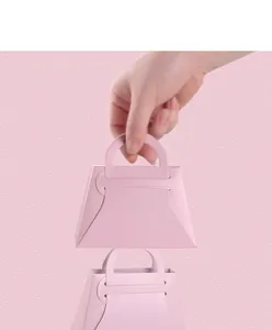Detalle de bolsa de regalo de papel rosa con textura mate y diseño de asa integrada