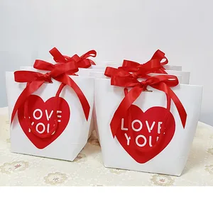 Close-up of red heart gift bag with LOVE YOU print and a silk bow decoration