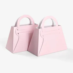 Minimalist pink paper wedding favor bags with a sleek handbag design and curved handles