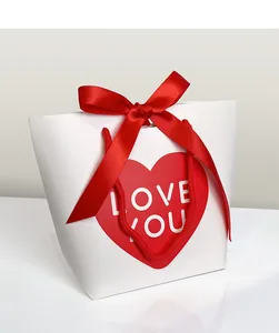 Close-up of white gift bag with red heart LOVE YOU text and satin ribbon bow