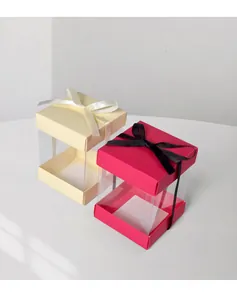 Vista macro di scatole regalo quadrate con finestra in PVC trasparente e fiocchi di seta