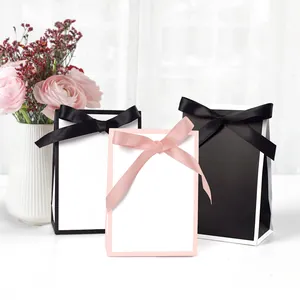 Sacs-cadeaux minimalistes en papier avec nœuds en satin noir, blanc et rose pour mariages