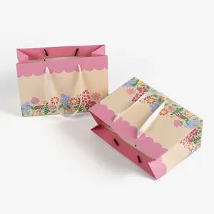 Floral print gift bags set with scalloped edges and white ribbon handles for presents