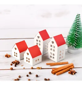 Macro view of house-shaped white paper gift boxes with red roofs and heart cutouts