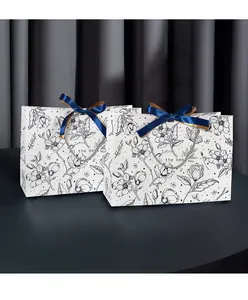 Detail of floral sketch gift bag with blue satin bow and All the best print