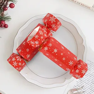 Creative red candy-shaped gift boxes with white snowflake patterns and gold ribbons