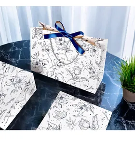 Detailed view of floral gift bags with navy satin bows and silver woven handles