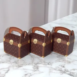 Drei braune Vintage-Geschenkboxen mit Goldschlössern auf weißem Marmorhintergrund