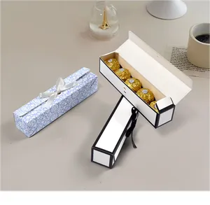 Detail van lange chocoladedozen met bloemmotieven en een strik voor vijf luxe bonbons