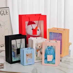 Vertical gift bags with transparent PVC window showing plush toys and ribbons