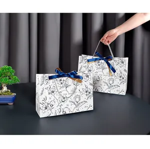 Detail of premium paper gift bag with floral prints and a silk bow on grey fabric