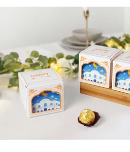 Close-up of white 3D cutout gift box with mosque motifs and orange Happy accent