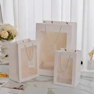 Set of white paper gift bags with transparent windows and blue woven rope handles