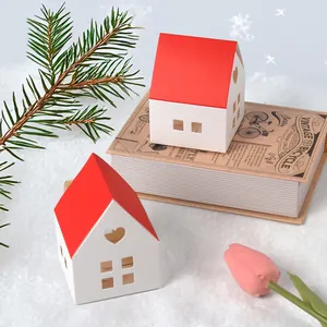 Red-roofed house-shaped gift boxes with heart cutouts on a winter-themed background